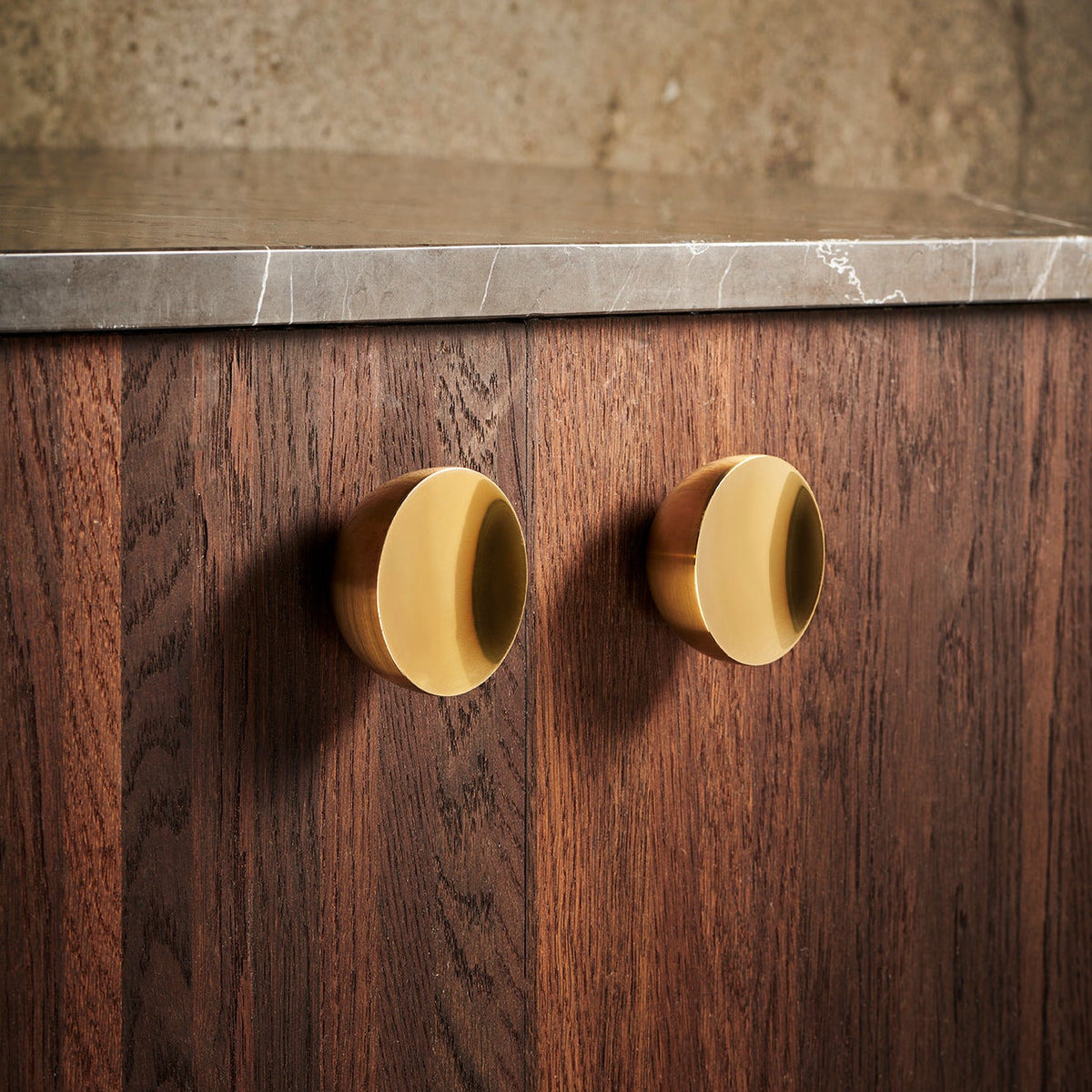 Get a Grip Cabinet Knob pair in Brushed Brass on walnut cabinet doors