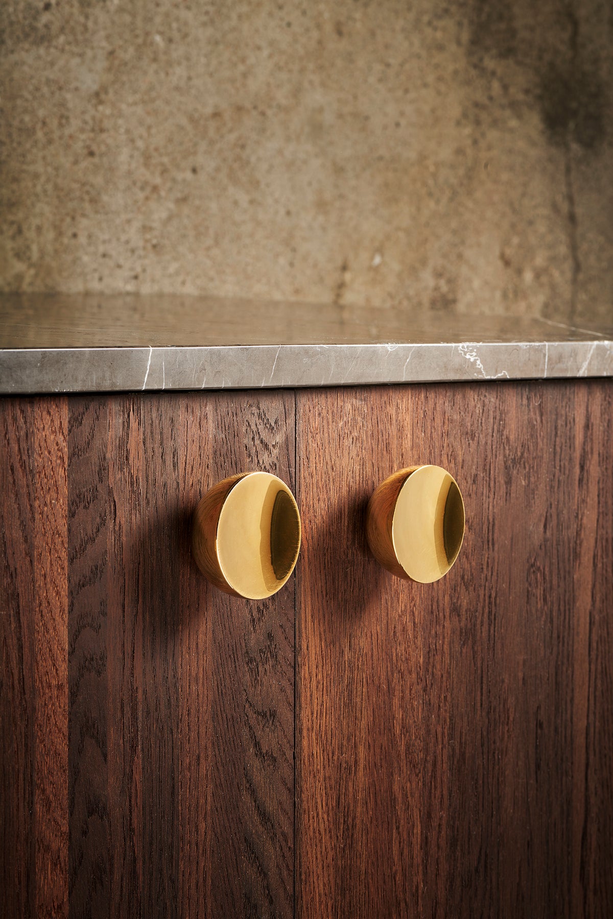 Get a Grip cabinet knobs in polished brass on a walnut cabinet by Maison Burgos