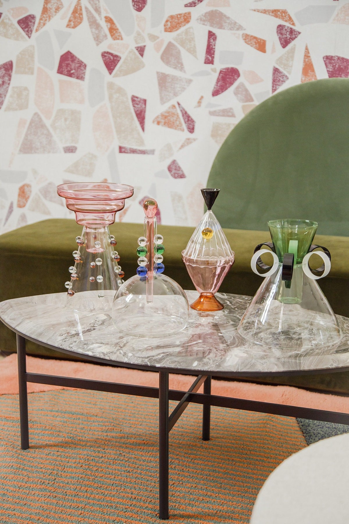 Horizon Sofa with sage green backrest behind a marble table with glass vessels