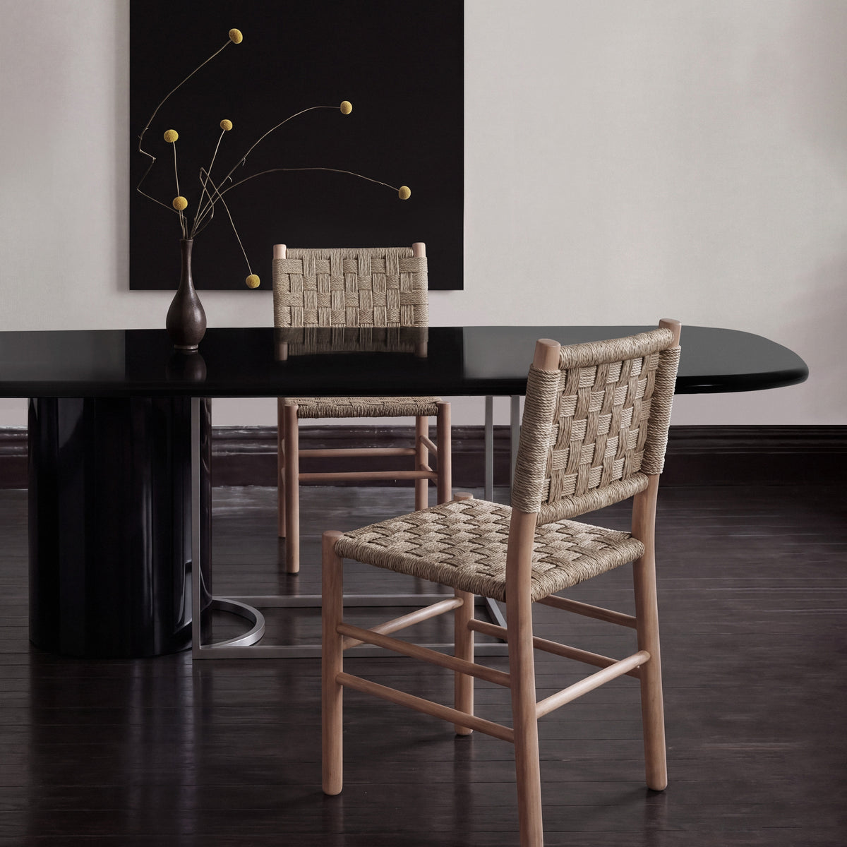 Horus Dining Table in black lacquer, closer view with two woven rush chairs