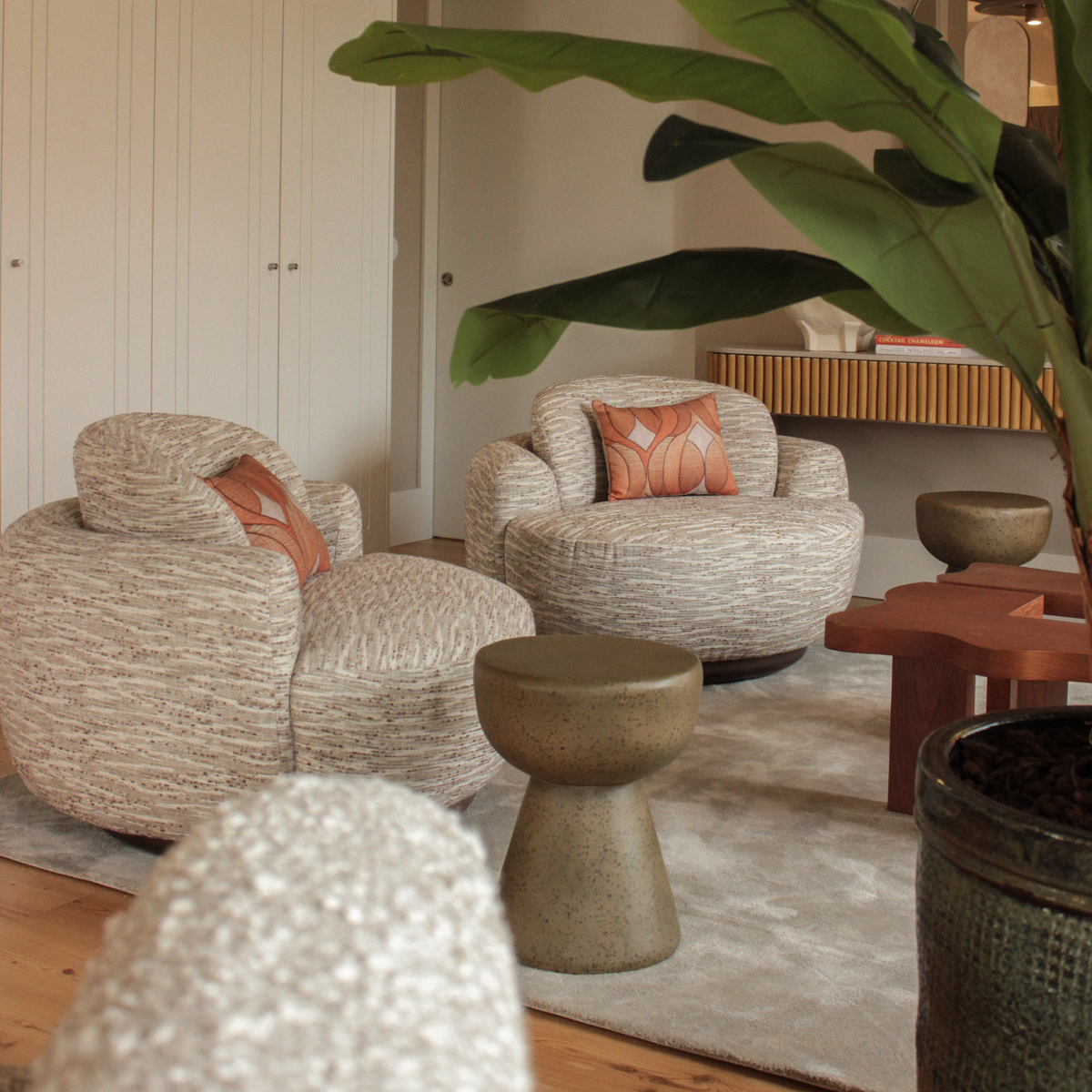 Naked Armchair pair in patterned textured weave in a living room with a banana plant