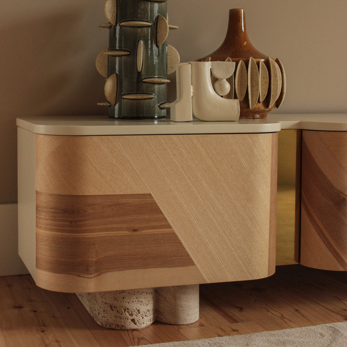 Kisho TV Stand close-up of the wood veneer door and travertine feet with vases