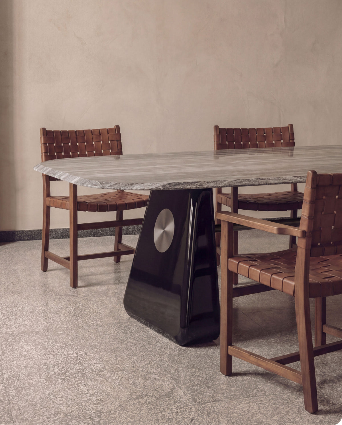 Inge Marble Dining Table with dark lacquered base and leather-strap chairs on a terrazzo floor