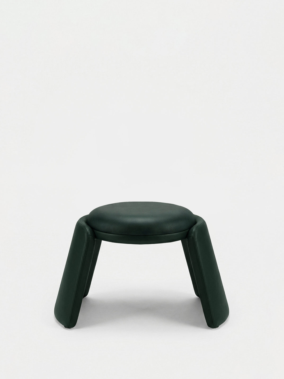 Inge Pouf in dark green leather, side view showing the curved legs