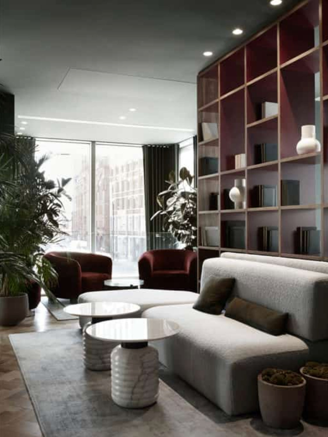Jean Side Tables with white marble tops in a modern lounge with grey sofas