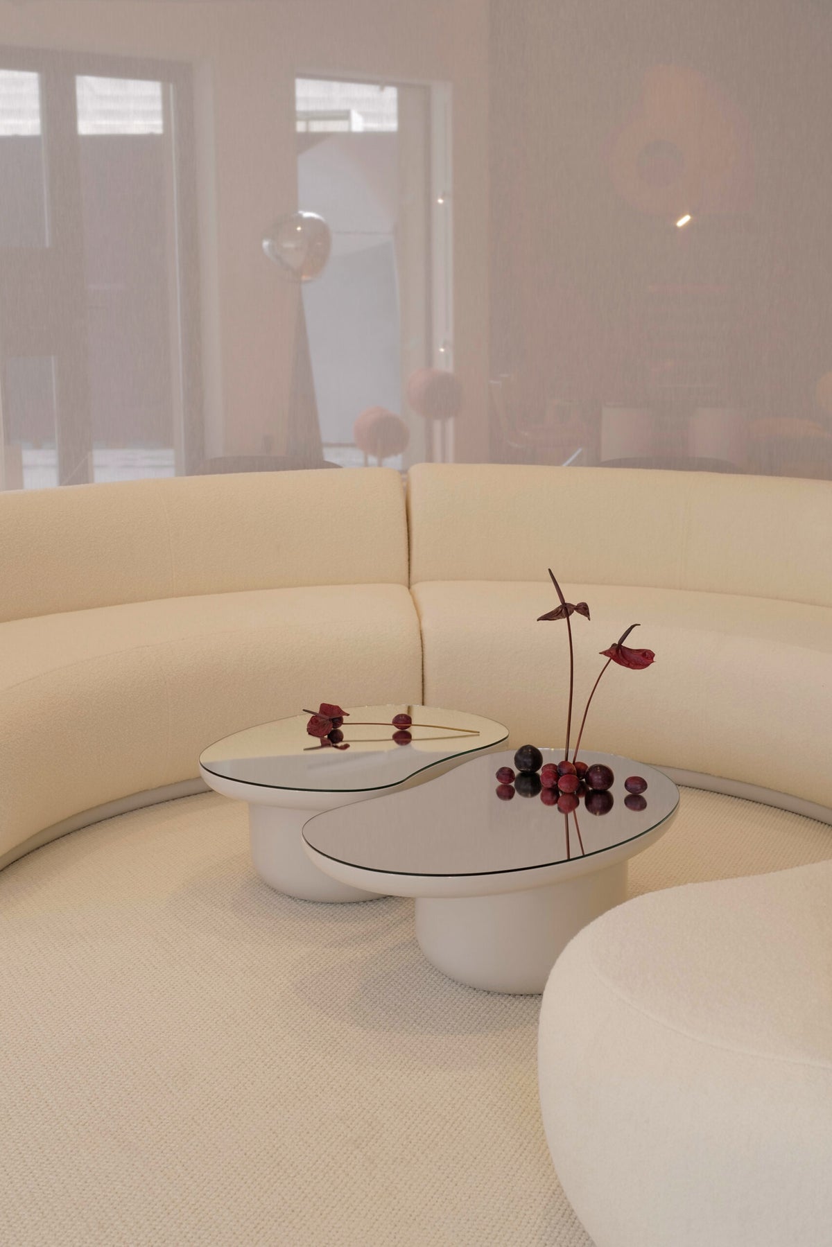 Laghi Coffee Table in white with a curved cream sofa and red flowers