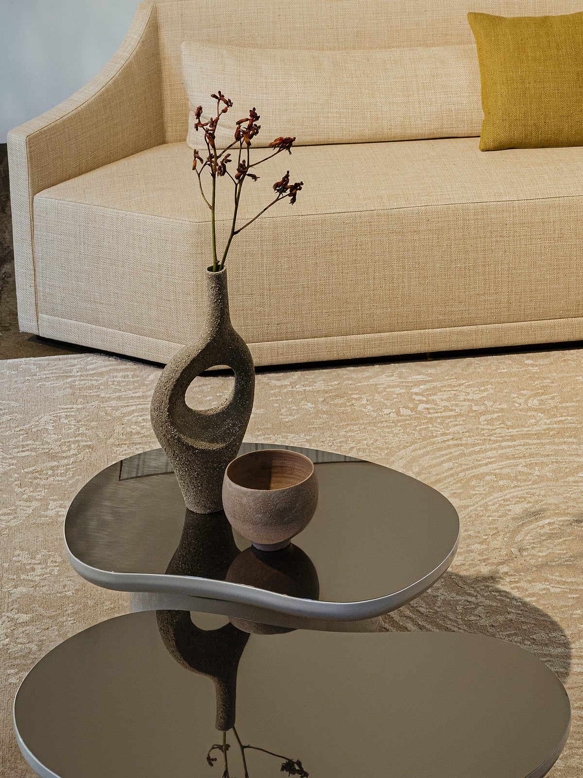 Laghi Coffee Table with dark glossy top styled with a sculptural vase