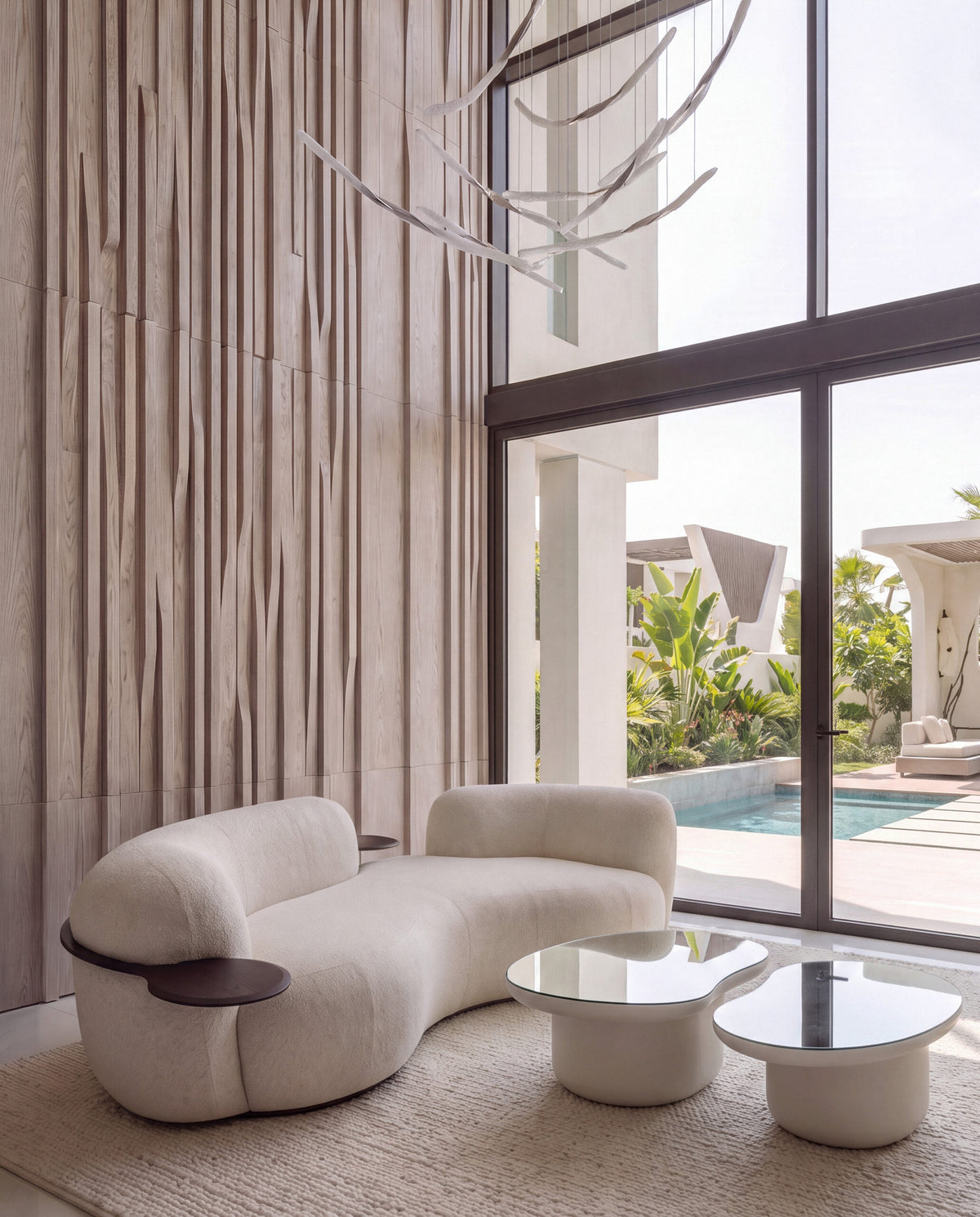 Laghi Coffee Tables in white beside a curved sofa in a room with pool views