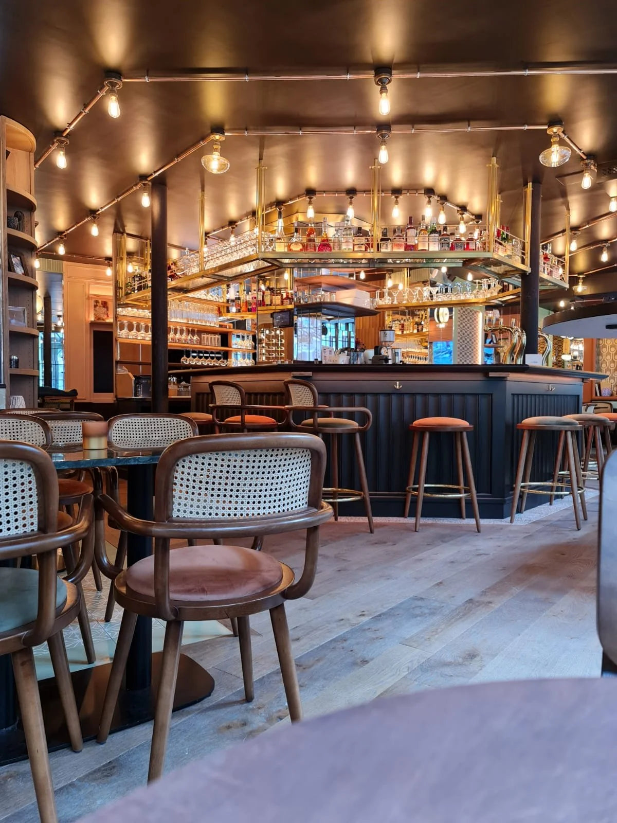 Luc bar stools along a wooden bar in a warmly lit restaurant