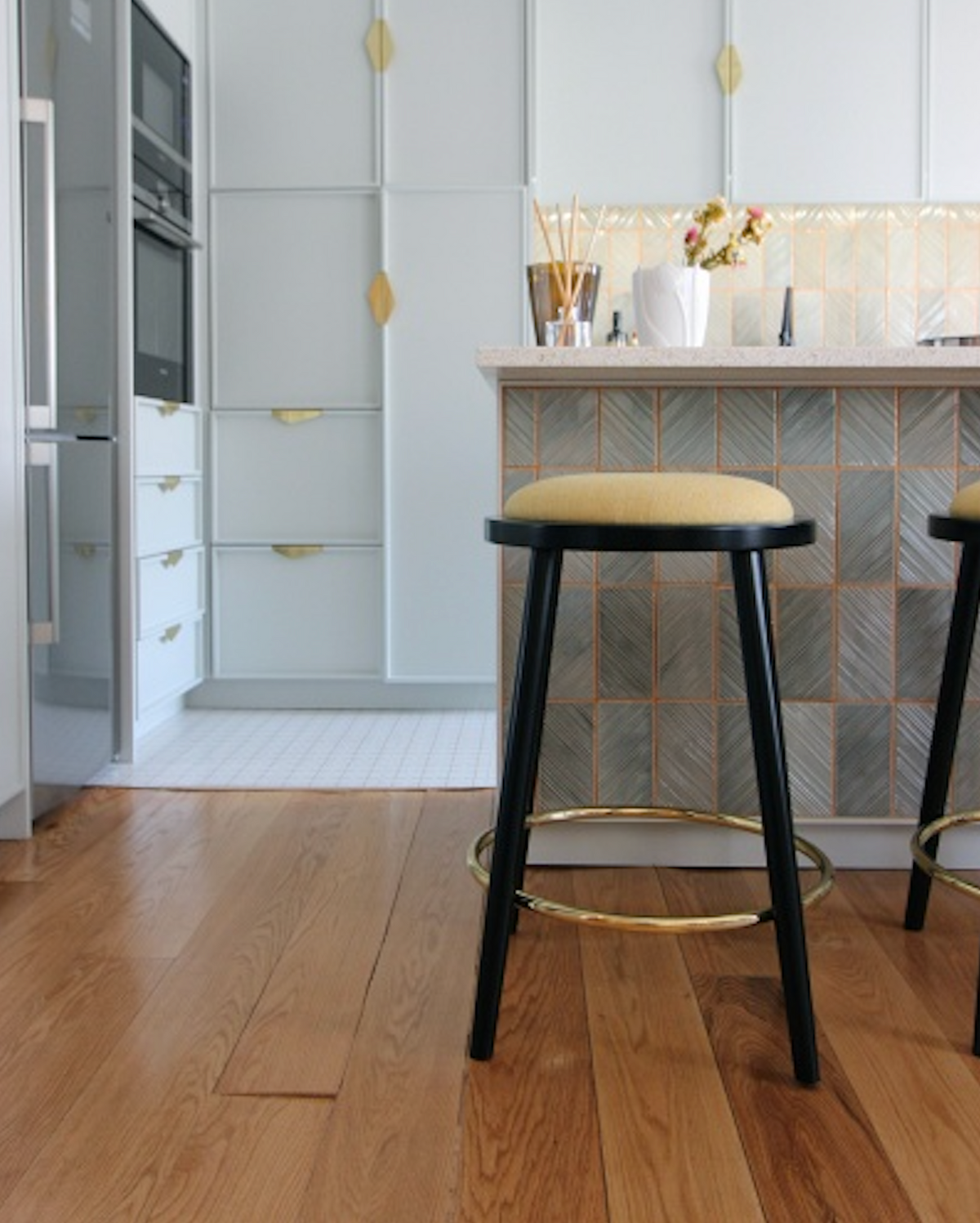Luc counter stool with mustard seat and black legs at a tiled kitchen island