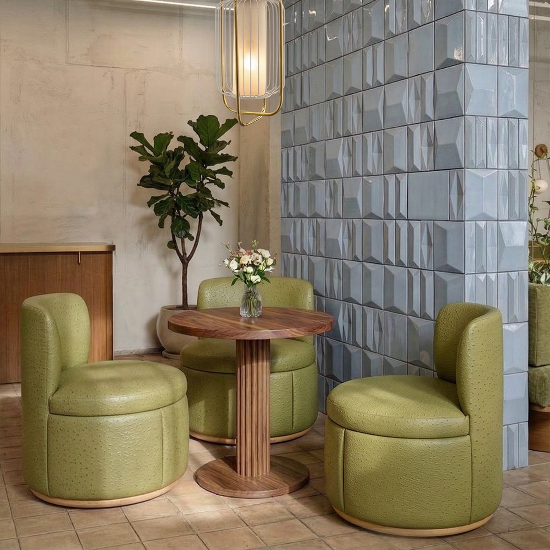 Mimi Swivel Lounge Chairs in green leather around a wooden café table by a tiled wall