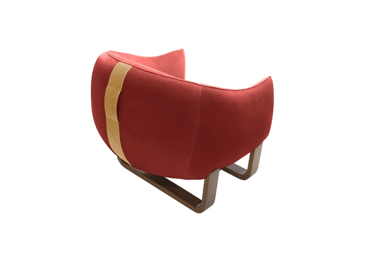 Milo Armchair back view in coral red velvet with tan leather strap and sled base