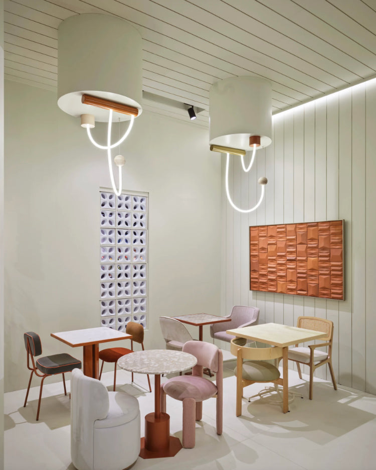 Mimi Swivel Dining Chair in a pale green café with sculptural pendant lights