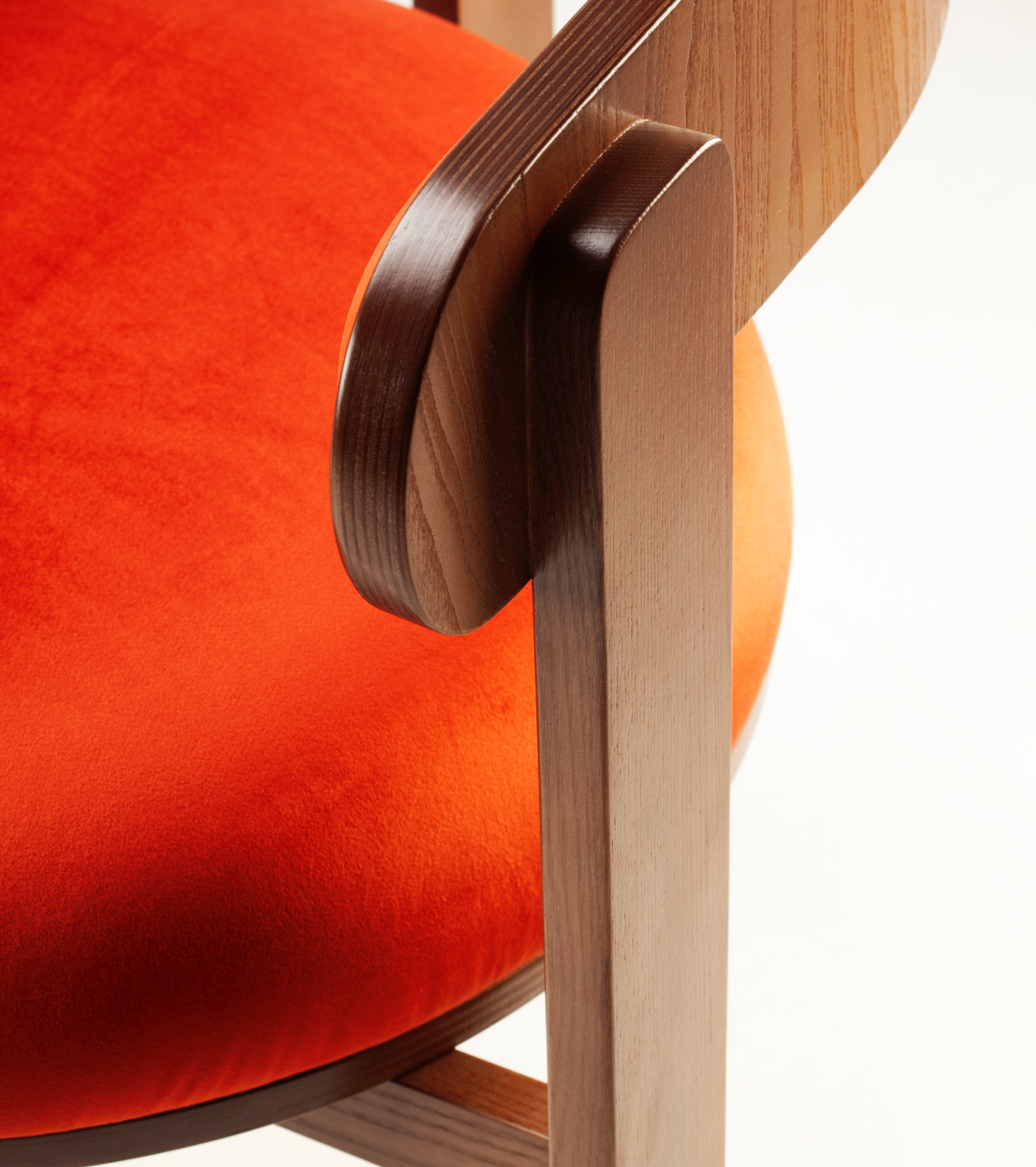 Moulin Dining Chair, close-up of the wood armrest joint against the orange velvet seat