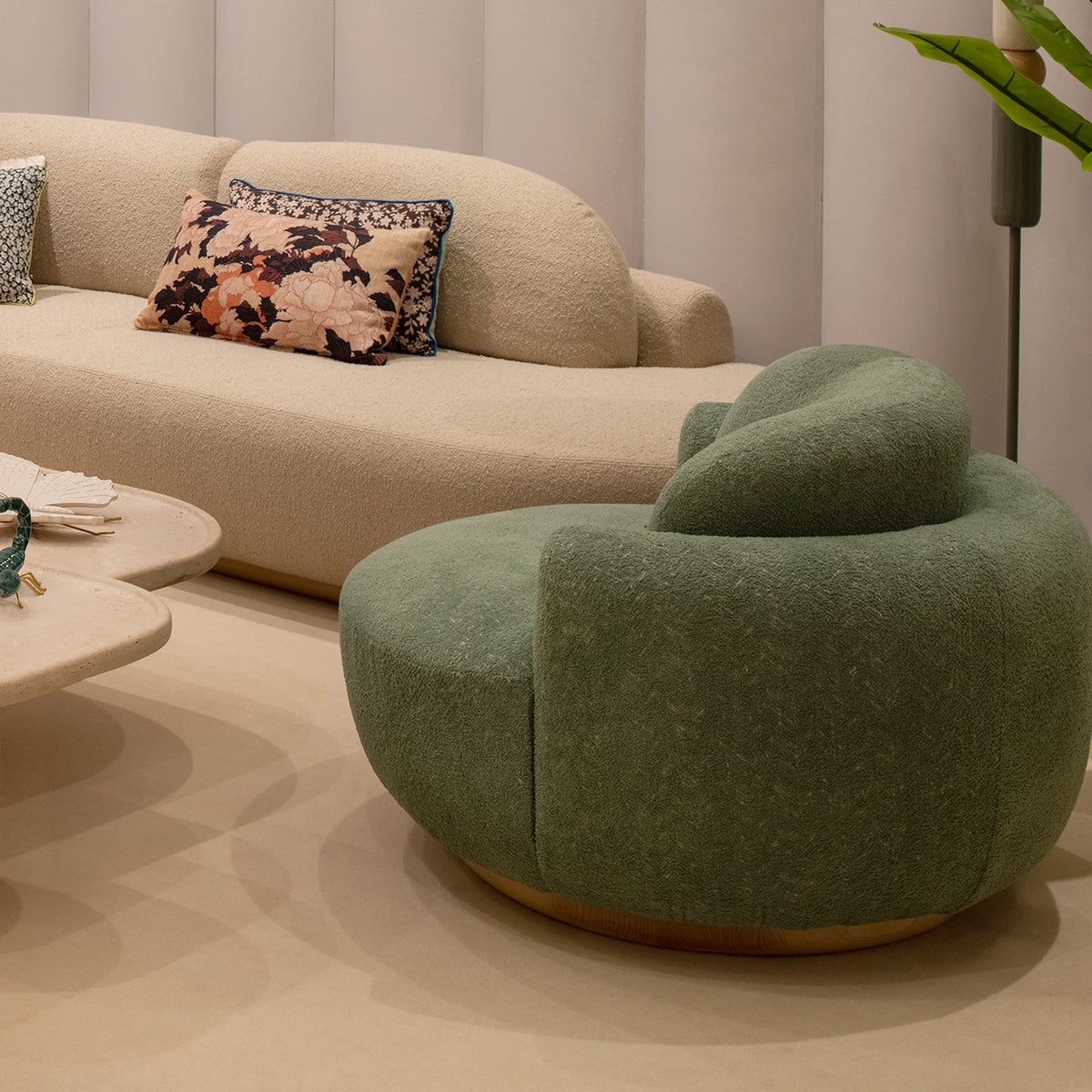 Naked Armchair in green Bouclé, rear view beside a cream sofa