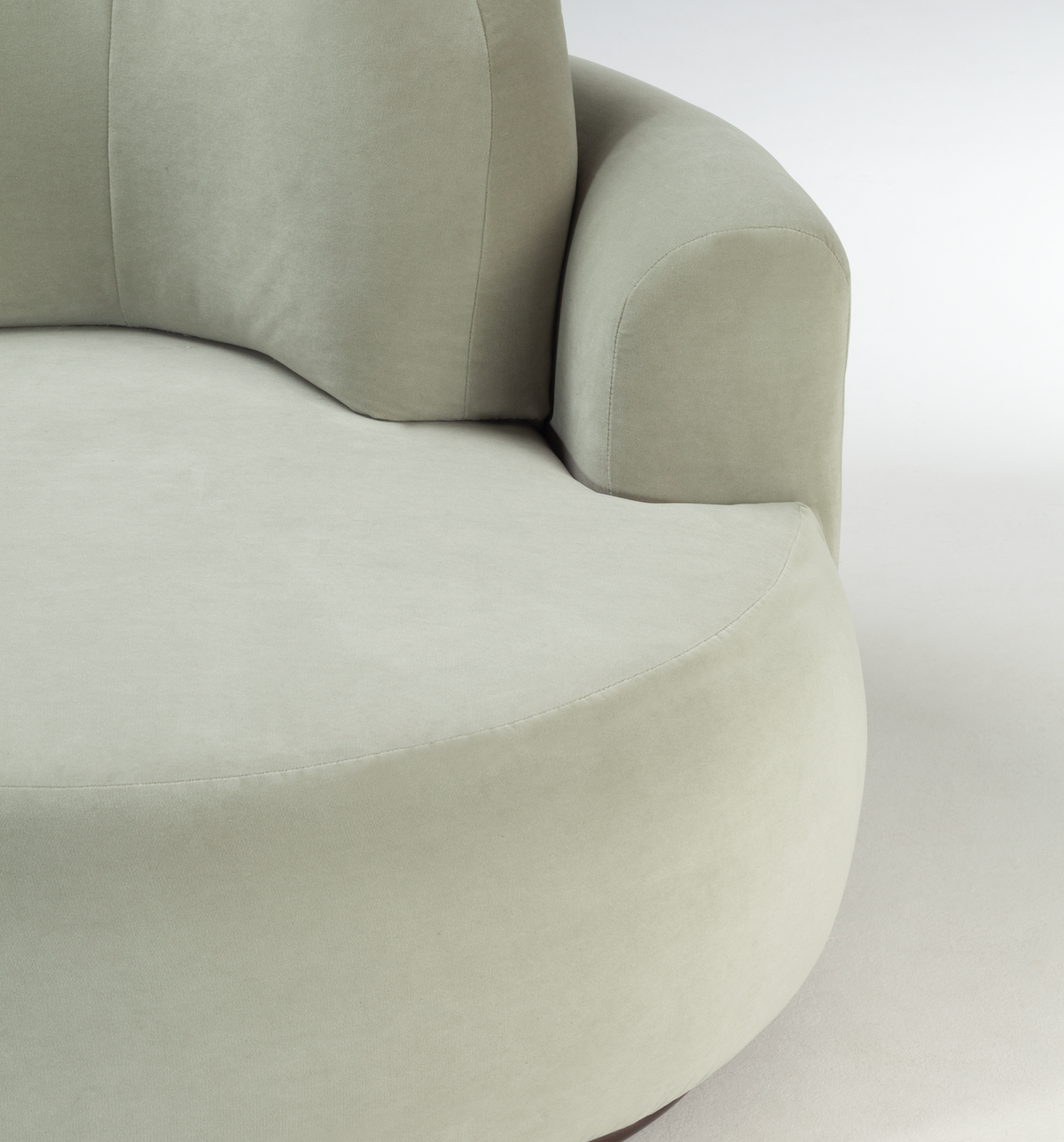 Naked Round Sofa close-up of the curved arm and seat in pale sage velvet