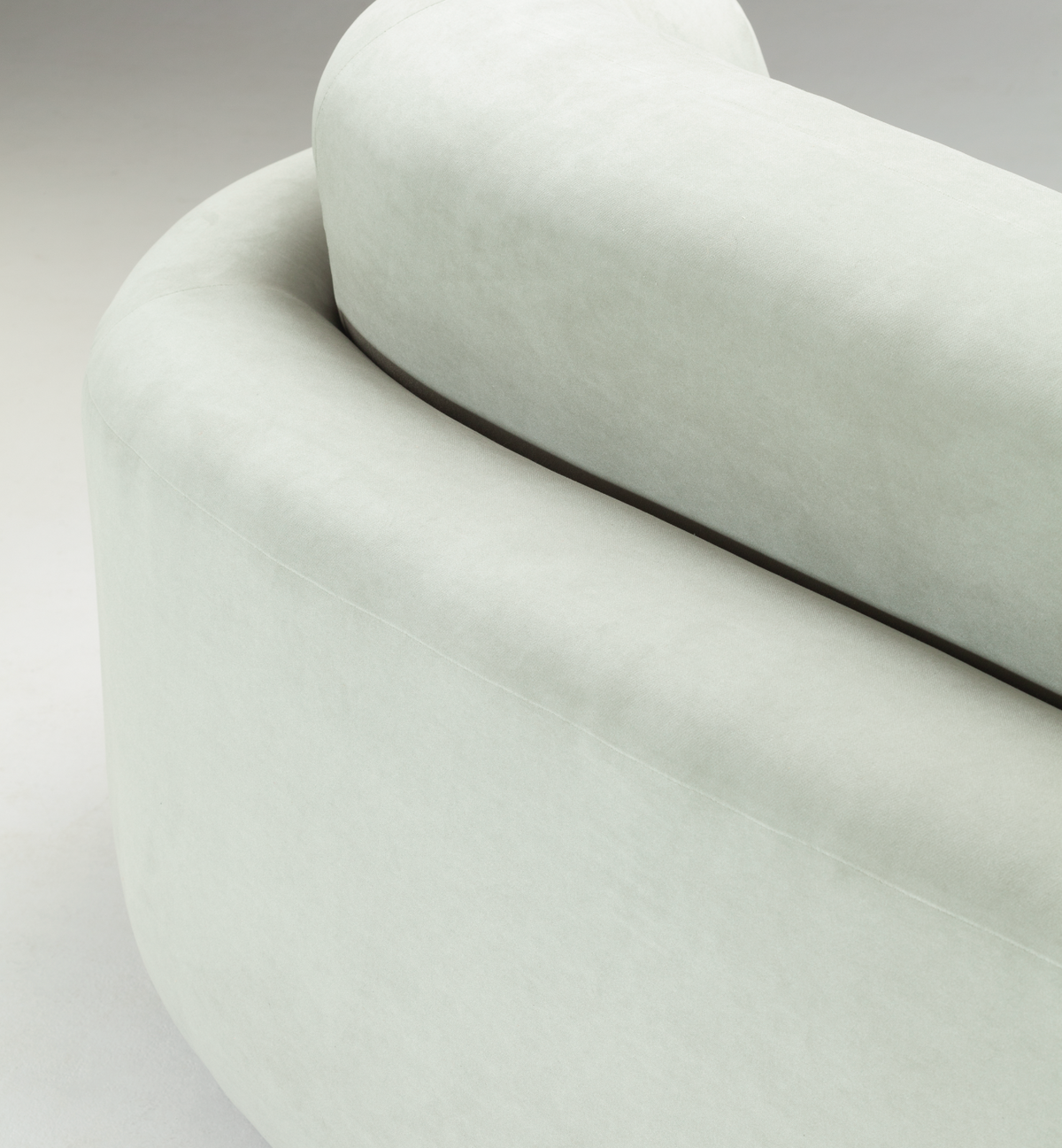 Naked Round Sofa close-up of the rounded back edge and dark base trim
