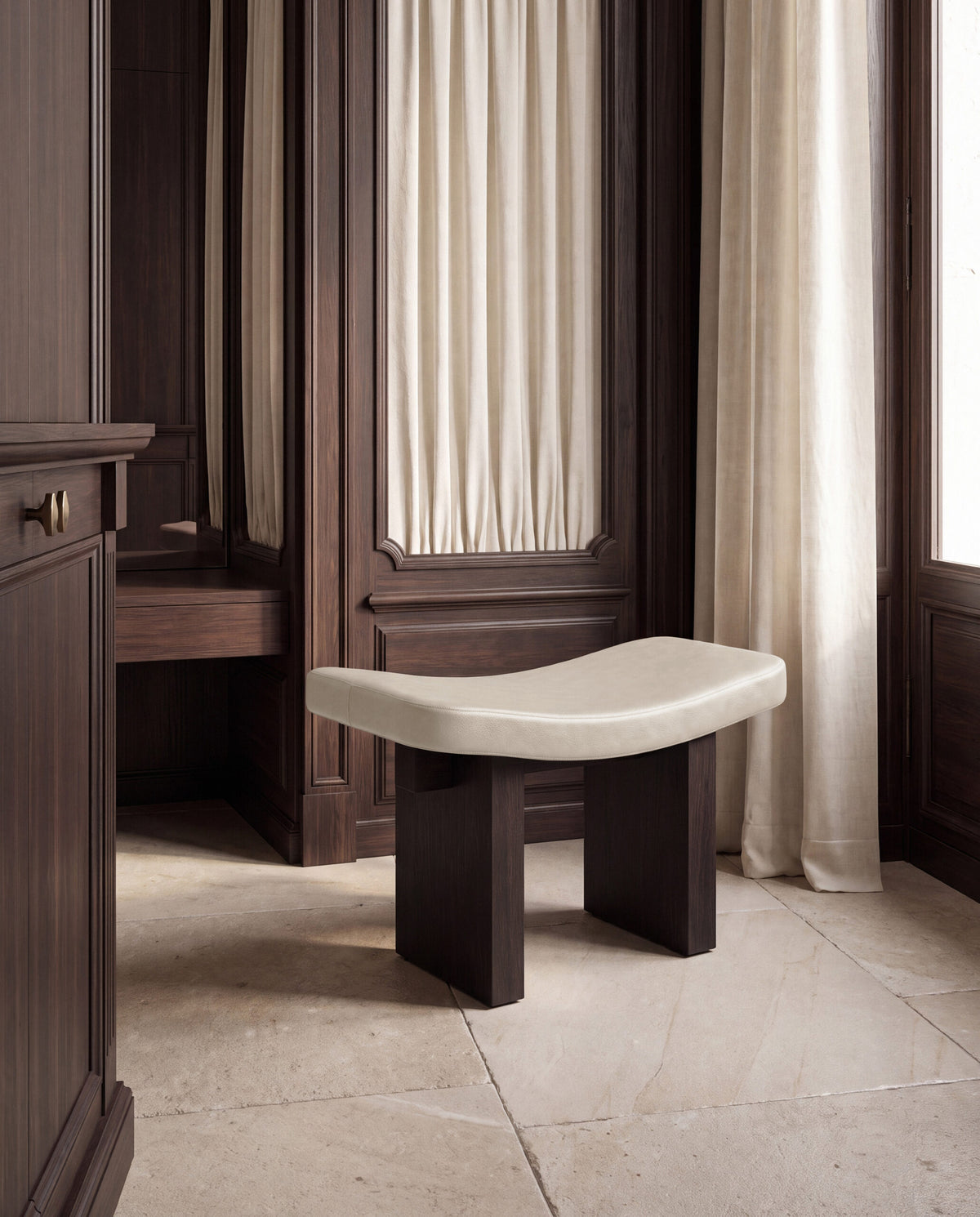Nara Ottoman in cream on dark wood in a panelled room with linen curtains