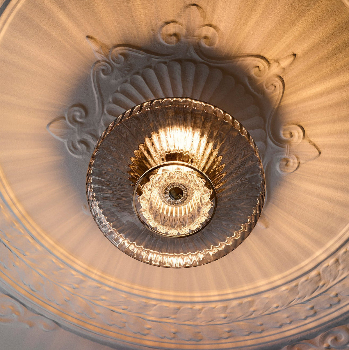 New Wave Optic Wall Sconce XL mounted on a ceiling inside an ornate plaster rosette