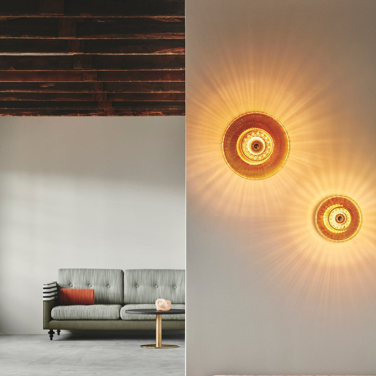 New Wave Optic Wall Sconce XL pair in amber glass on a wall in a living room with a grey sofa