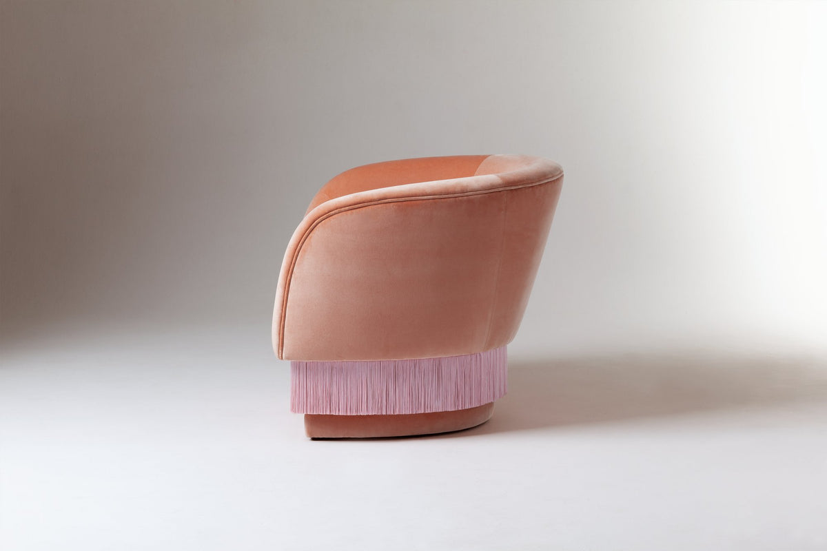 La Folie Armchair in pink velvet, side view of curved back and fringe