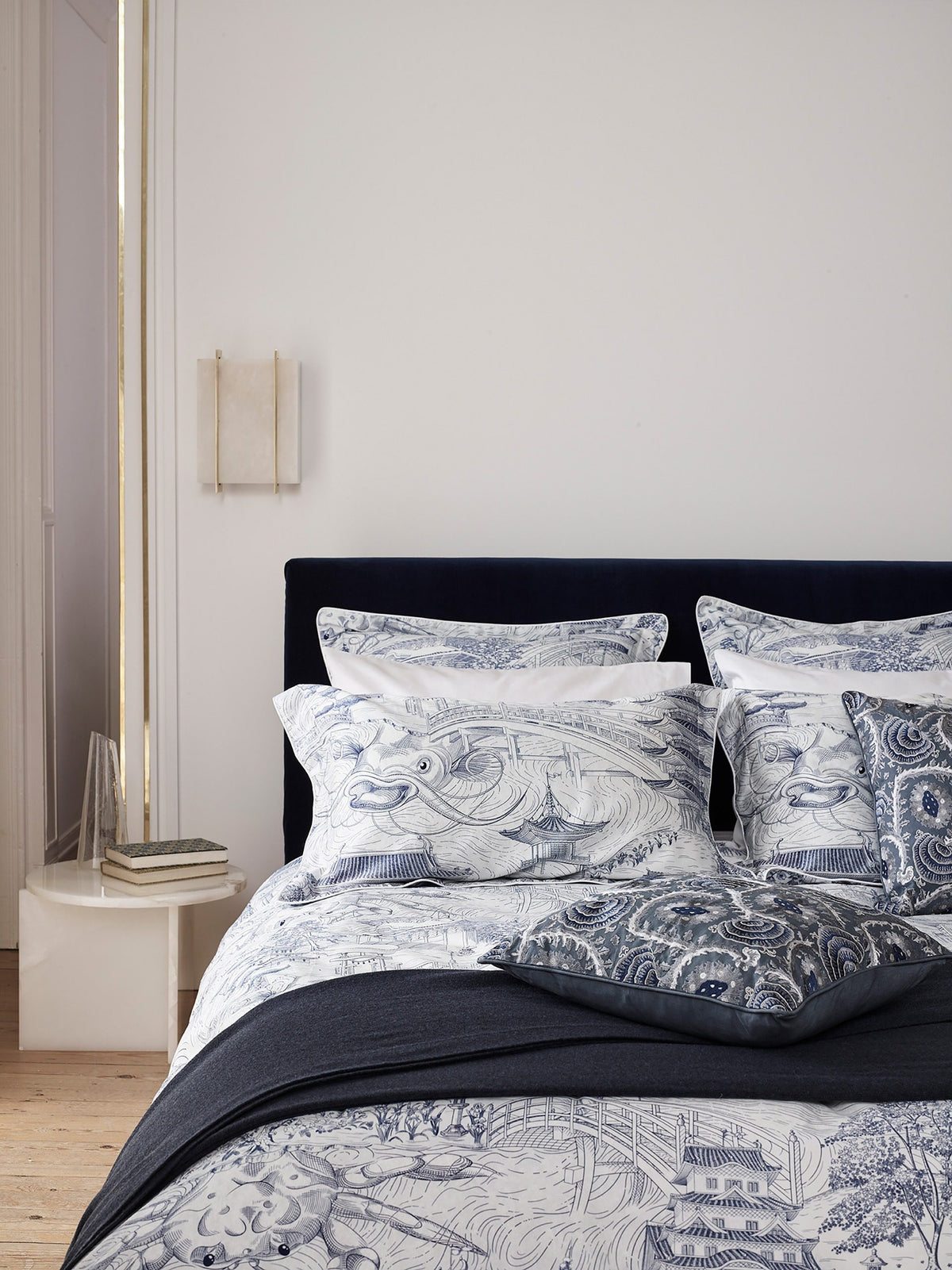 Origin Side Table in white marble as a nightstand beside a toile bed