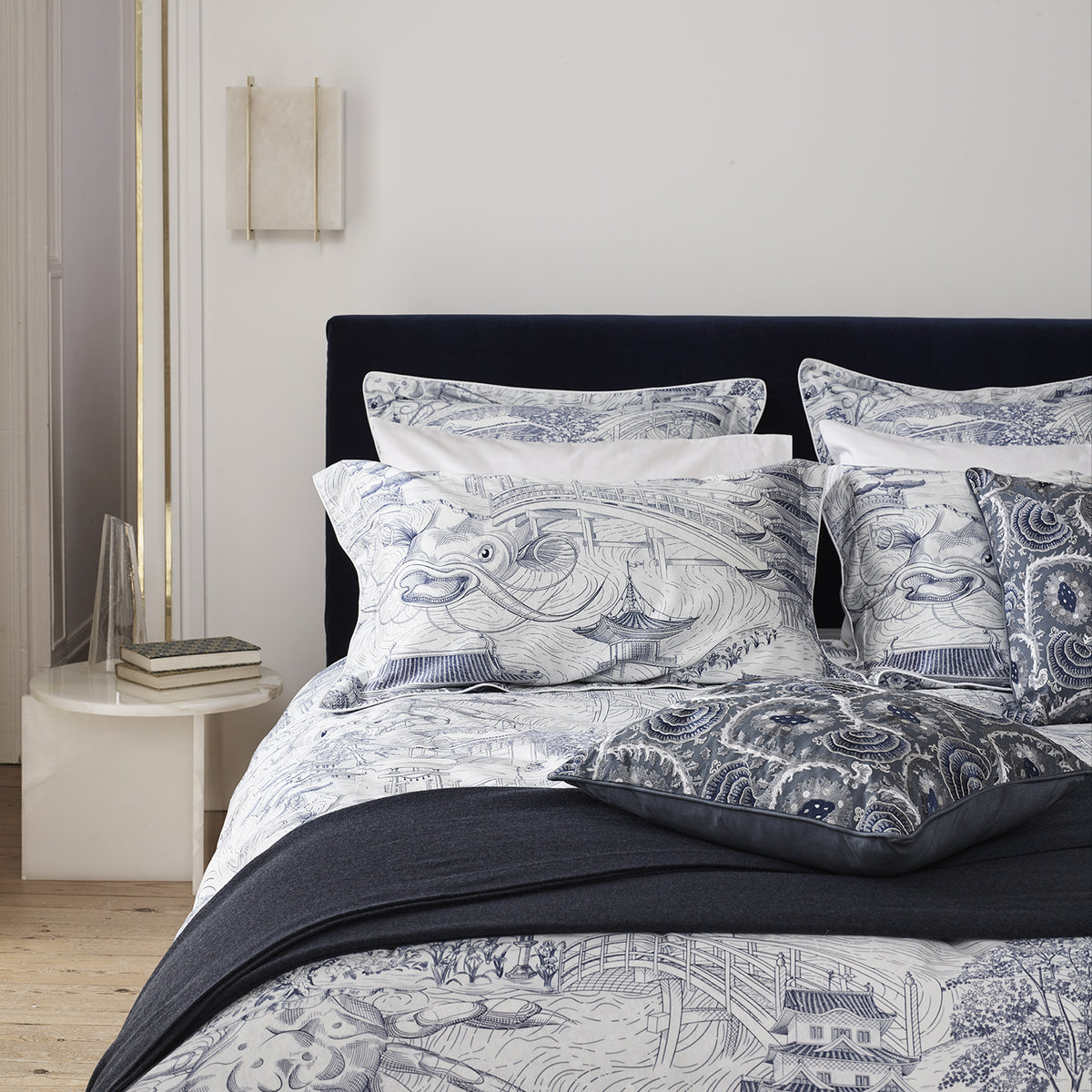 Origin Side Table in white marble beside a bed, close view