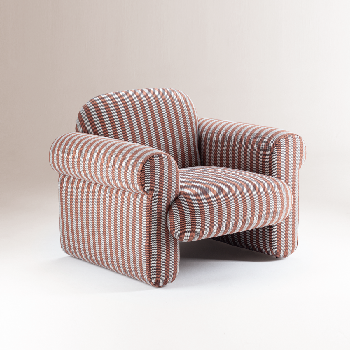 Oscar Armchair in rose and grey stripes, three-quarter view on a studio backdrop