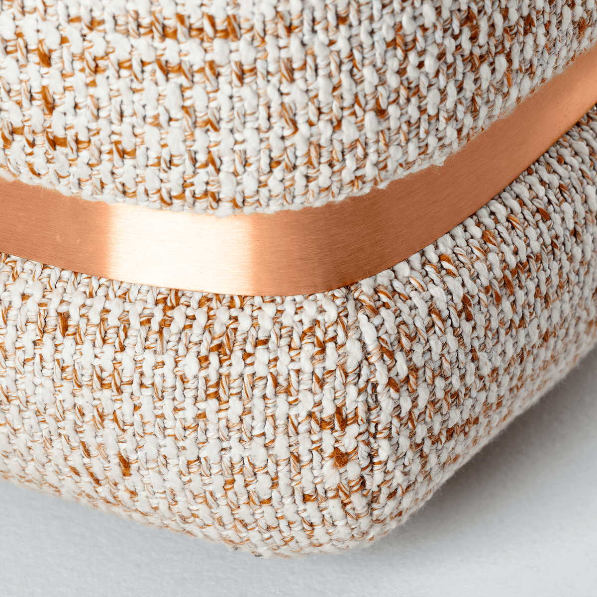 Panorama Armchair close-up of copper trim on speckled bouclé base