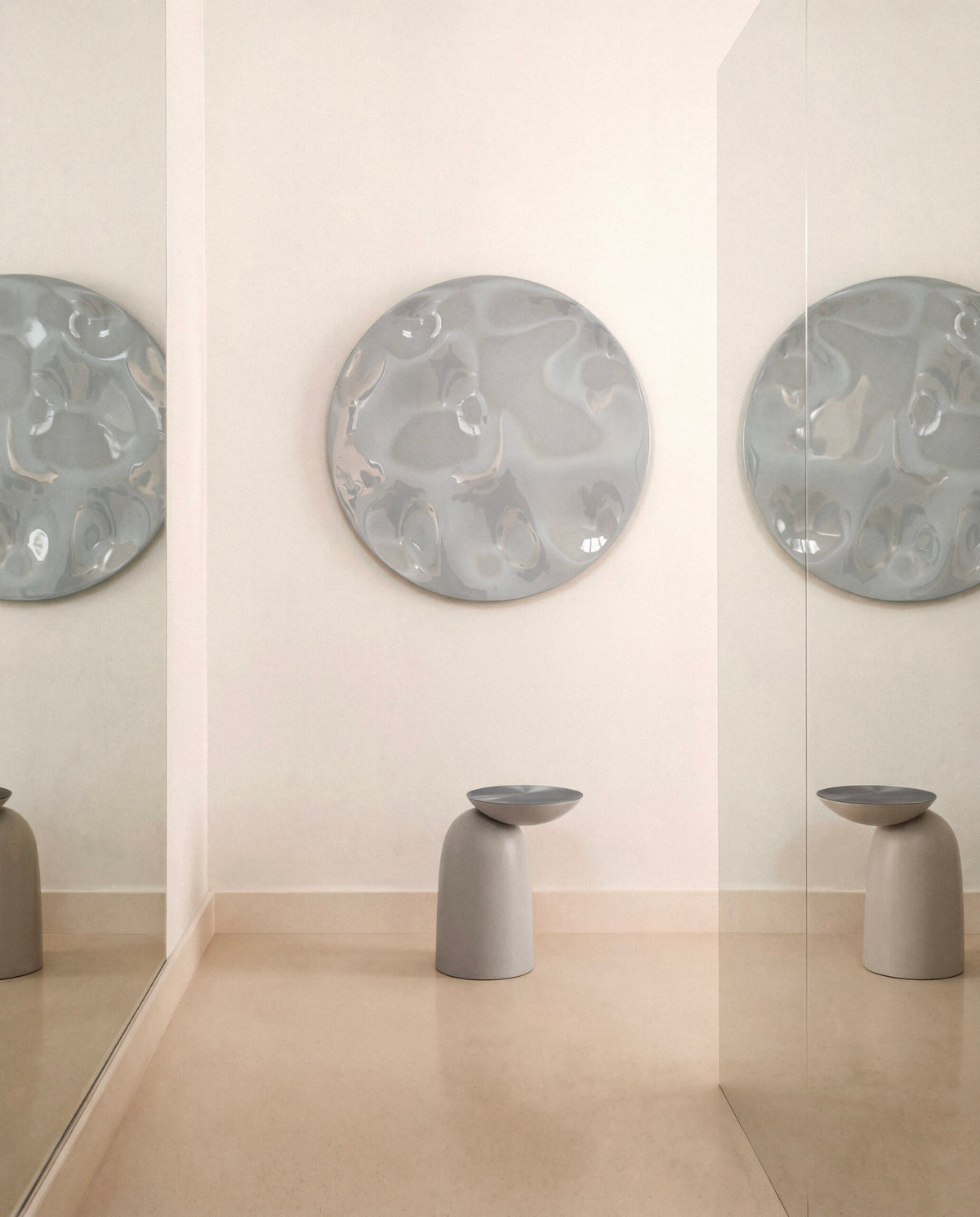 Pingu Side Tables in taupe in a blush-toned hallway with round wall art