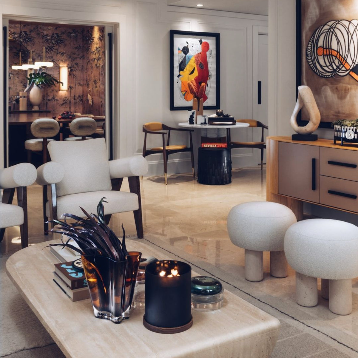 Playing Games Travertine Coffee Table in a dining-lounge with bouclé stools and dark glass decor