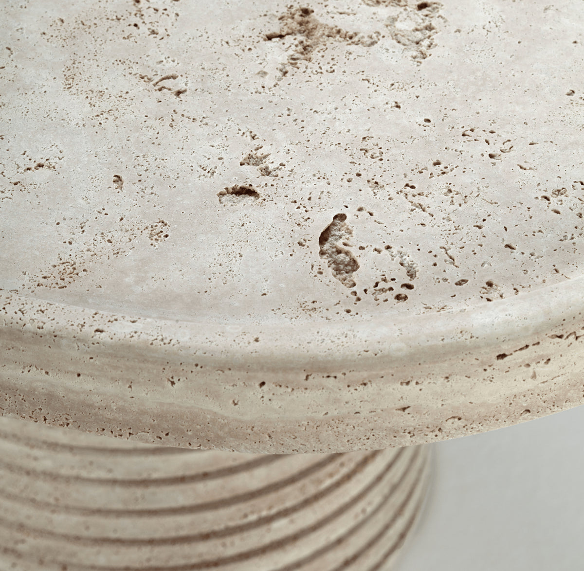 Poppy Side Table close-up of the travertine top edge and ribbed base