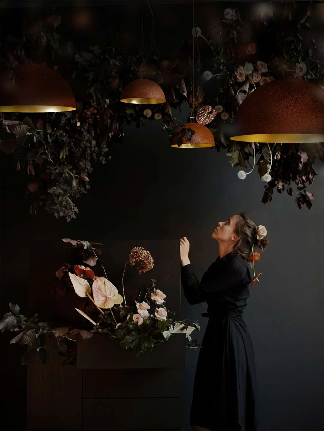 Mammalampa Queen Pendant Light, Large, pendants among dried blooms as a woman looks up