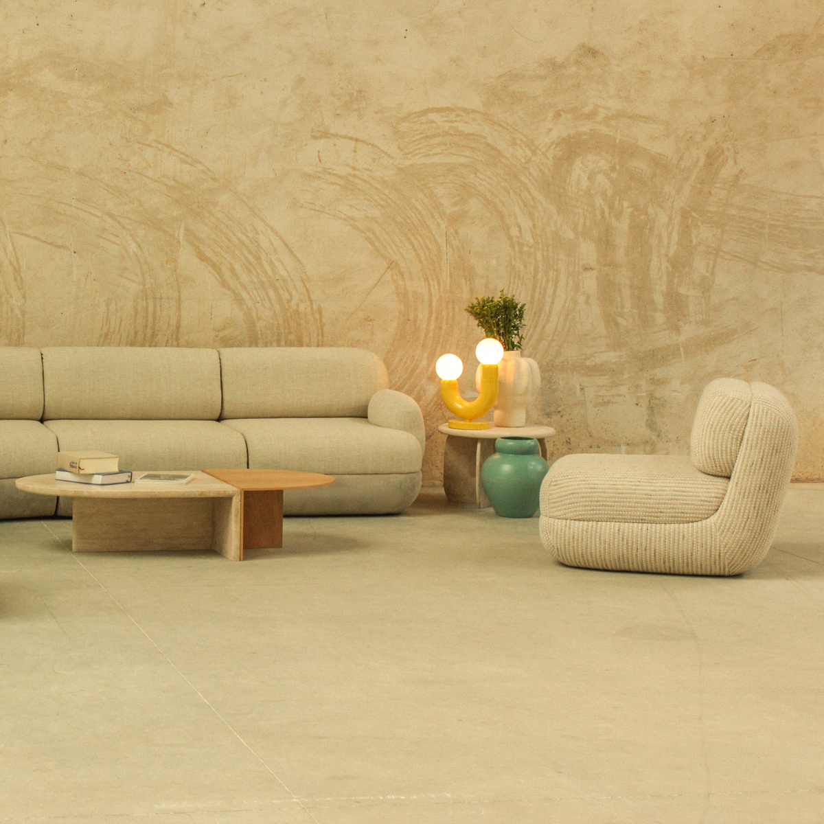 Mood Lounge Chair beside a matching sofa and low tables in a plaster-walled lounge
