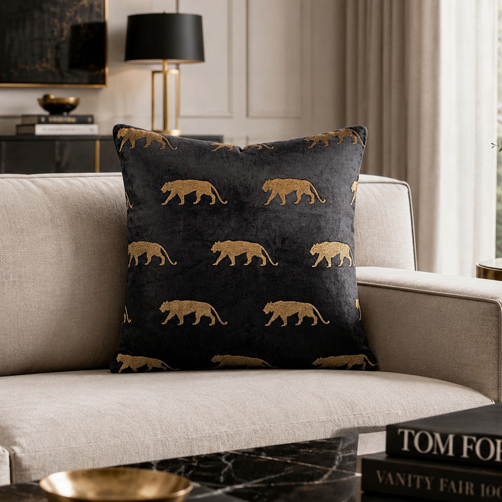 Rica Embroidered Pillow Square in Black with gold leopards on a cream sofa