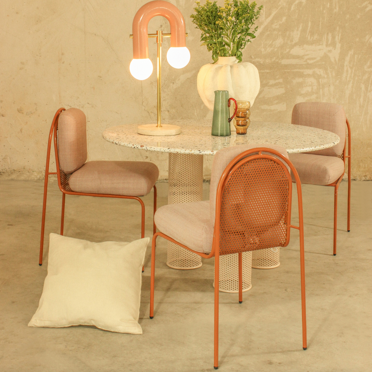 Riviera Chairs in blush with perforated back around a terrazzo dining table