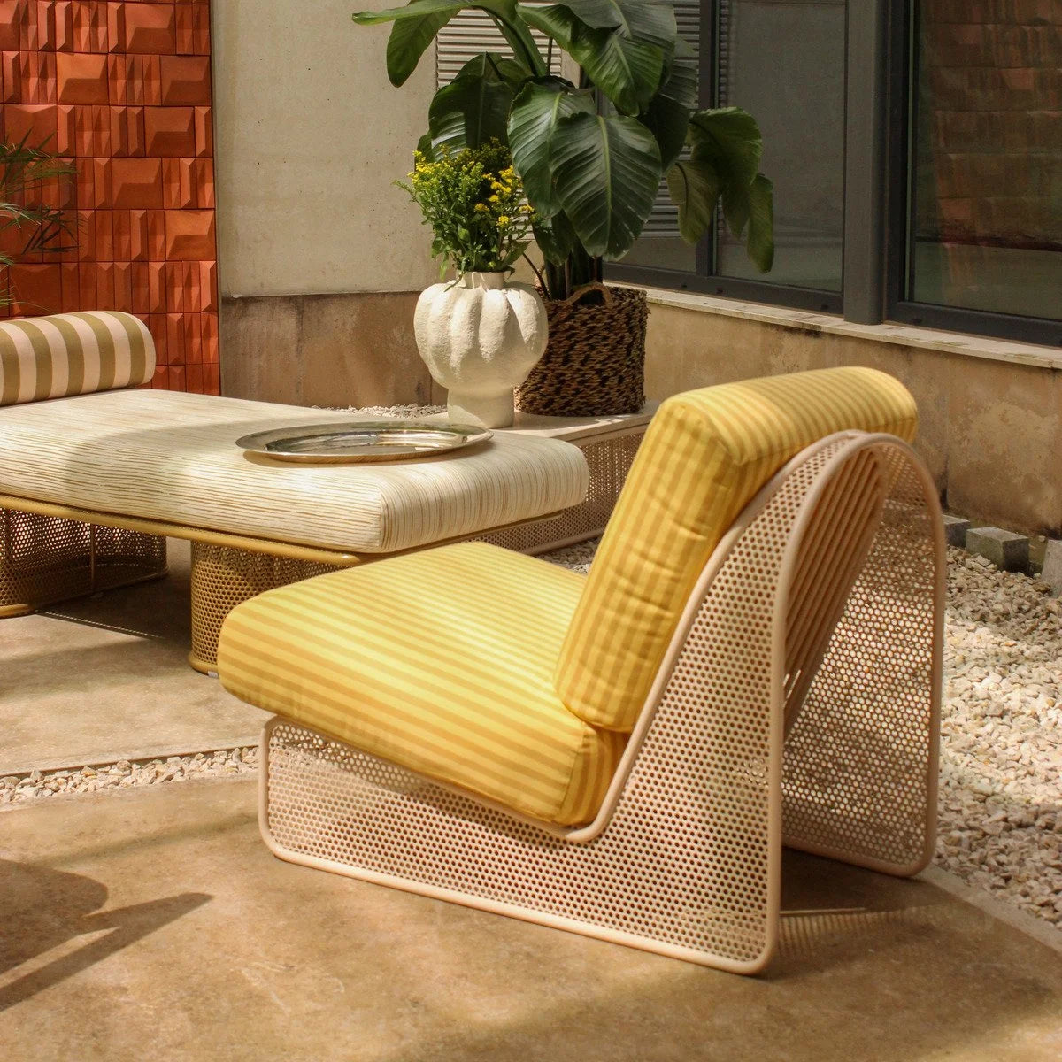 Riviera Armchair with yellow stripe cushions and perforated frame on a patio