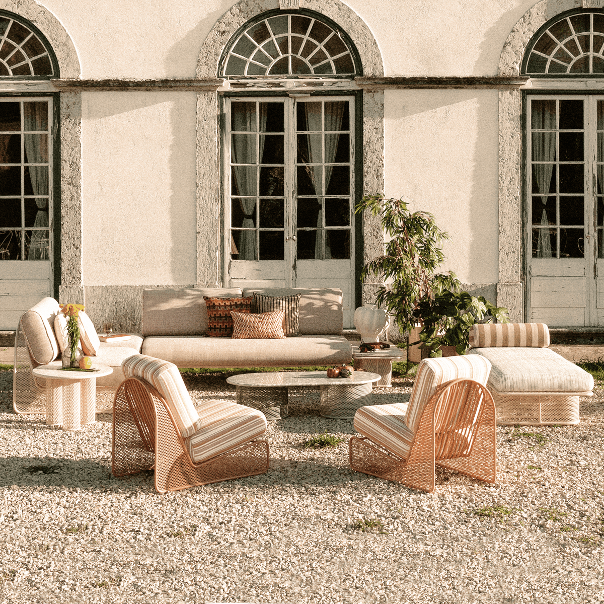 Riviera Coffee Table in a full outdoor lounge set before a classical facade