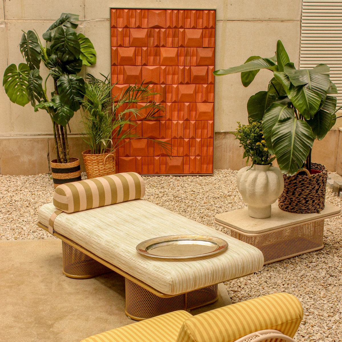 Riviera Modular Coffee Table with a striped chaise and plants on gravel