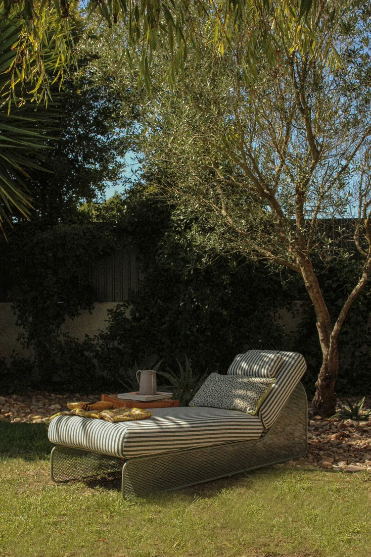 Riviera Daybed with striped cushion in a garden