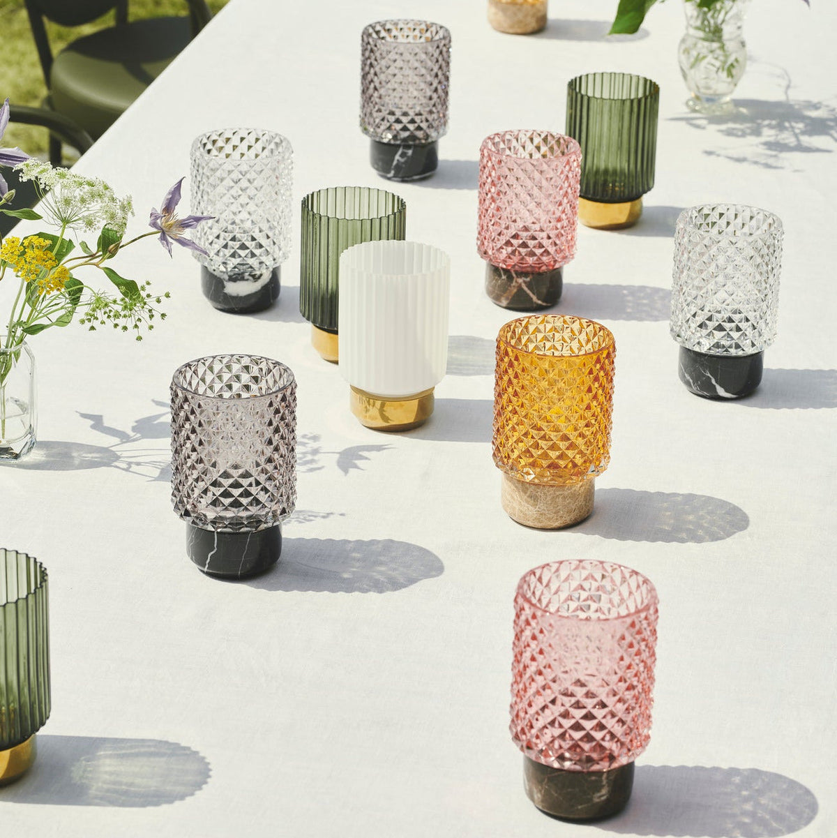 Sons of Marble Candle holder hurricane collection in Smoke, Rose, Amber and Clear across a white table