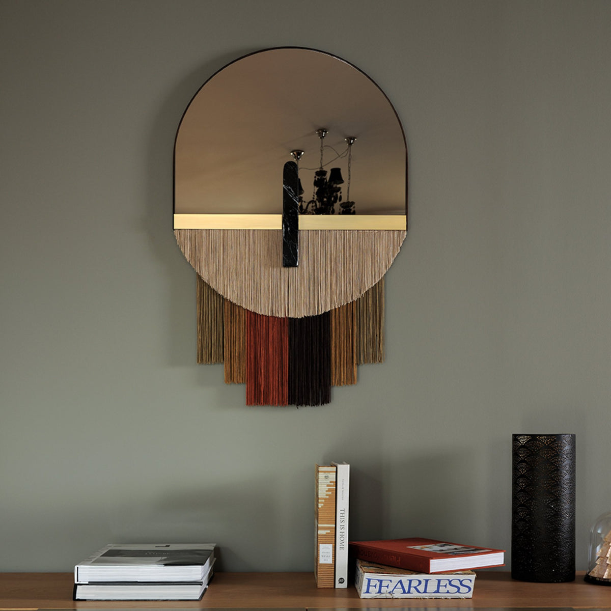 Souk Mirror Caramel with multicolor fringe above a console with books