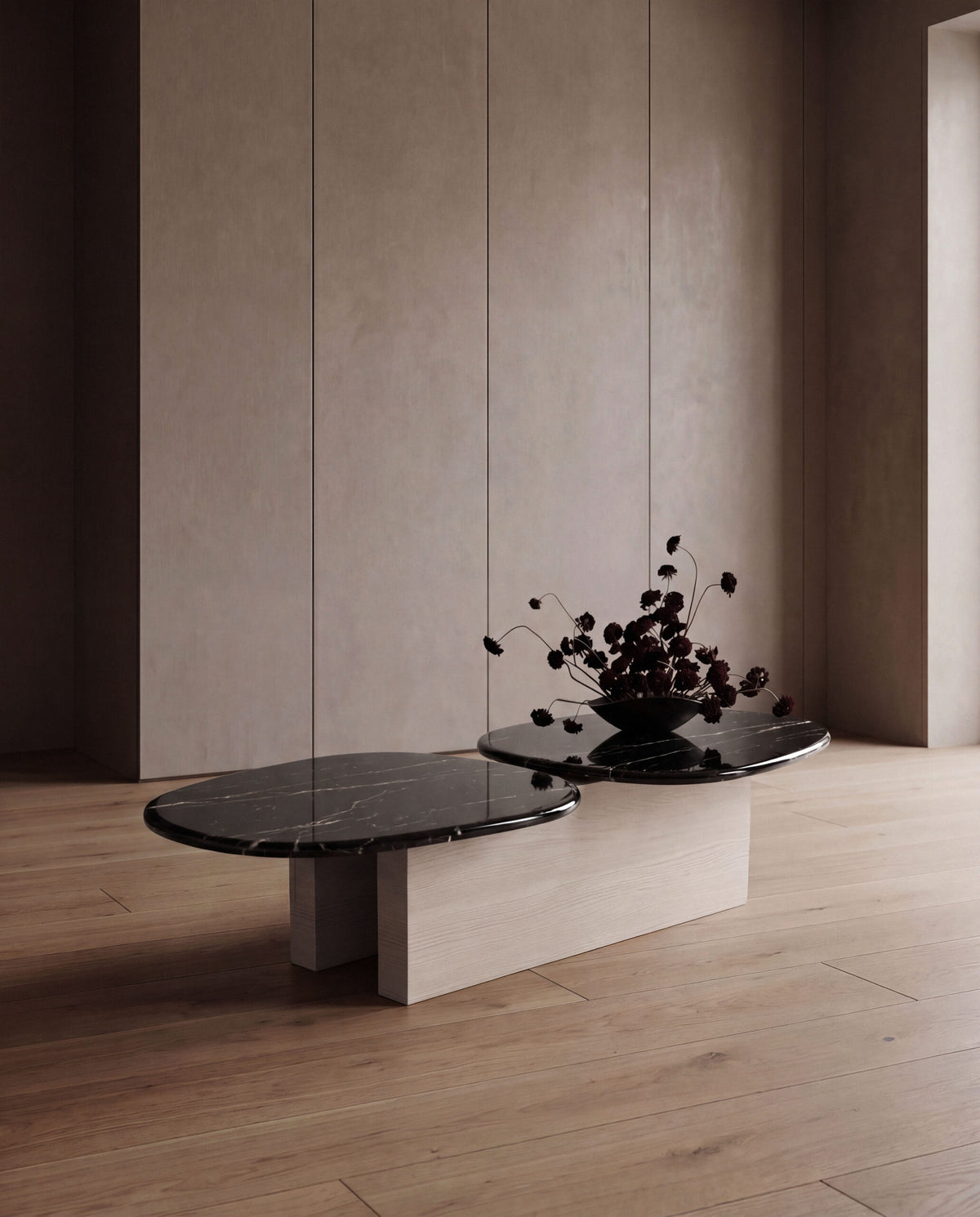 Taras Coffee Table with black marble tops on light oak with dark flowers in a minimal room