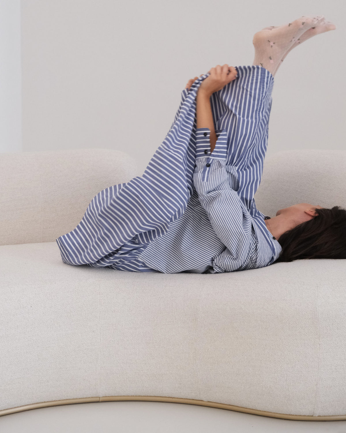 Tateyama Cloud Sofa seat detail with brass base trim and person lounging