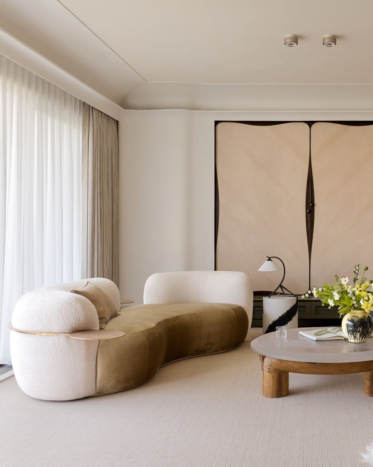 Tateyama Curved Sofa in cream and olive velvet beside a round coffee table