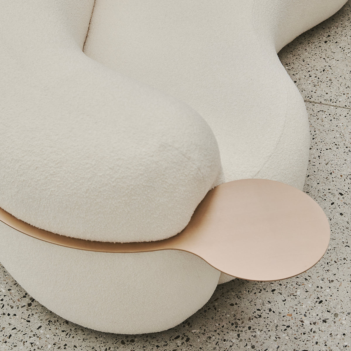 Tateyama Curved Sofa, close-up of the curved boucle end and blush metal tray