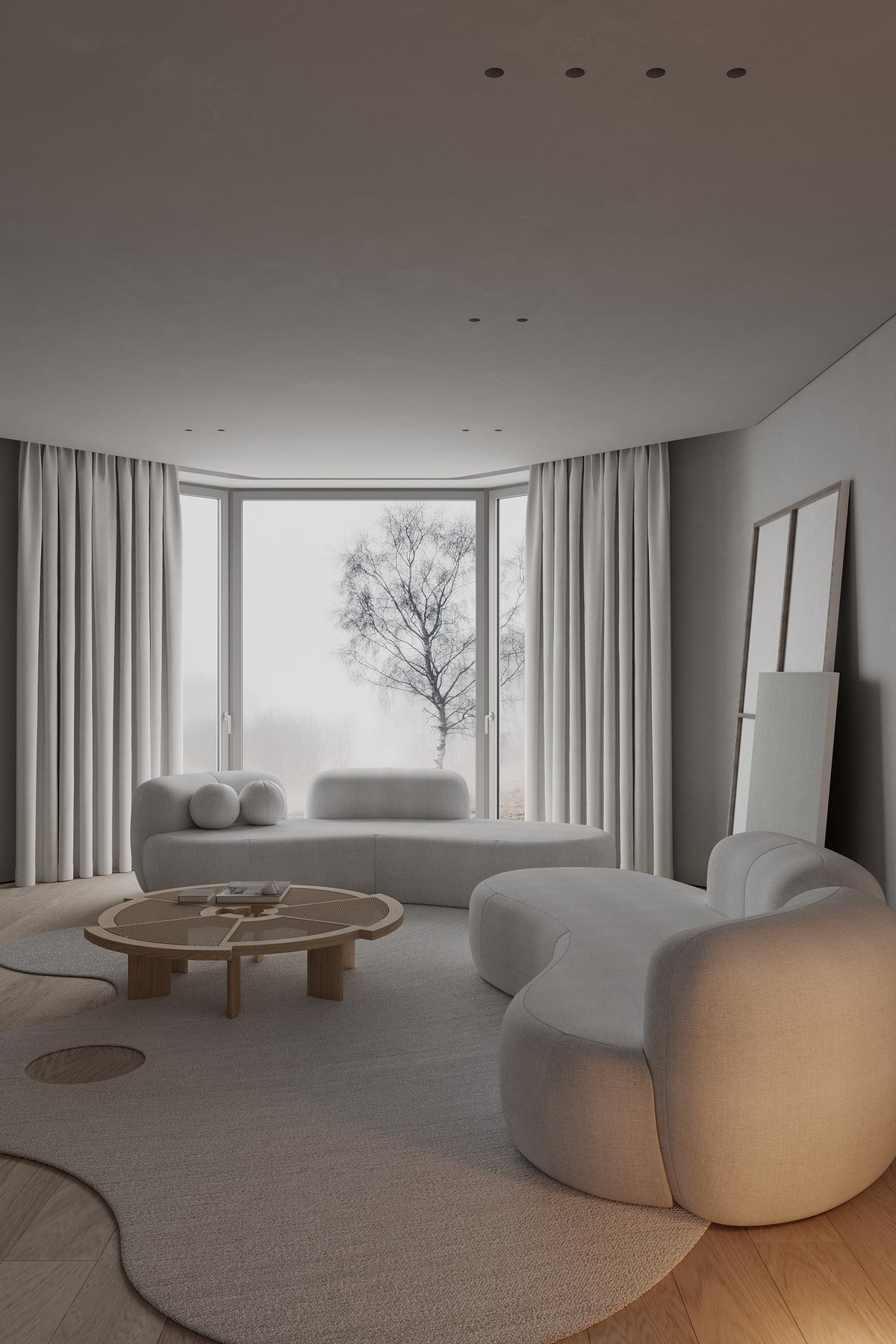 Tateyama XL Sofa in white boucle with a round wood coffee table by a winter window