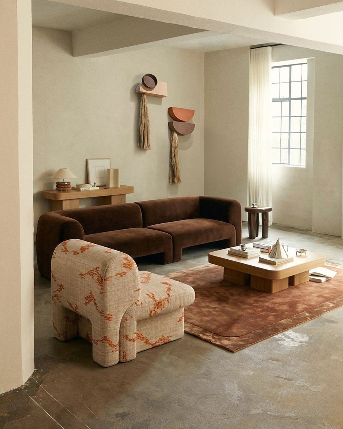 Slide Sofa in brown velvet in a loft living room with a patterned armchair