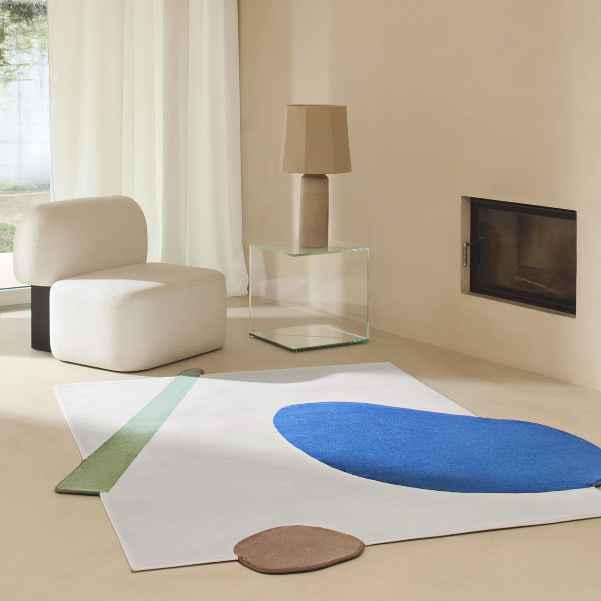 Yemeni Lounge Chair in cream on a blue abstract rug near a glass side table