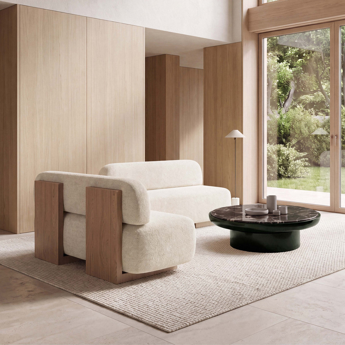 Yoshida Sofa left view in ivory bouclé beside a dark round coffee table